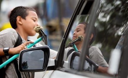 Limpieza.  Un niño trabaja limpiando los vidrios.