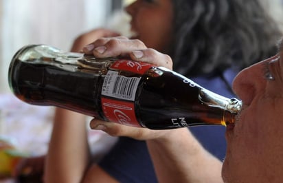 Refresco. Fotografía de un hombre que bebe una conocida marca de refresco. 