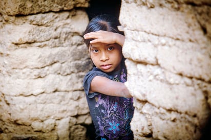 Servicios. Una pequeña indígena se aprecia en uno de los cuartos de adobe donde las familias viven hacinadas; aunque sus moradas tienen piso, carecen de los servicios básicos. 