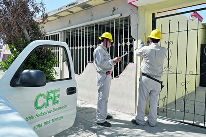 Trabajadores. En la fotografía se observan dos colaboradores de la CFE revisando un medidor.