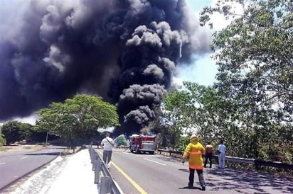 Bomberos trabajan para sofocar llamas.