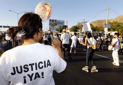 Integrantes de la asociación Manos Unidas por Nuestros Hijos colocaron mantas en las afueras de los accesos a la residencia oficial para reiterar su demanda de justicia. (Archivo)