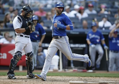 José Bautista llega a la registradora ante los Yanquis. (AP)