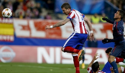 El delantero croata del Atlético de Madrid, Mario Mandzukic (i), cabecea para conseguir el tercer gol 'colchonero' ante Olympiacos. (Fotografías de EFE)