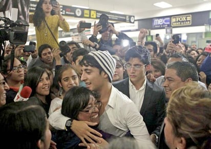 A las 19:50 horas salió de las puertas de arribos internacionales donde ya lo esperaba un centenar de personas con pancartas, entre ellas sus padres y hermanos. (El Universal)