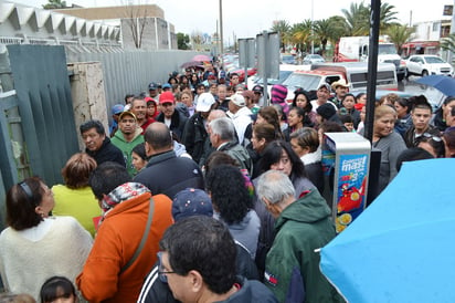 Toleran. Con frío y lluvia, derechohabientes del IMSS esperaron por horas para surtir sus recetas.