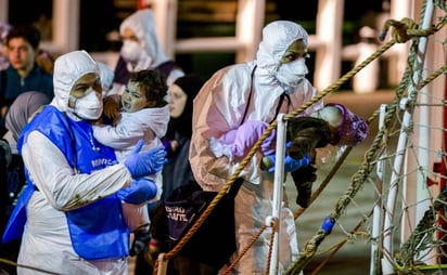 Ayuda. Rescatistas italianas ayudan a los niños que fueron auxiliados tras el naufragio del barco portugués.