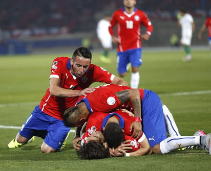 Los jugadores chilenos celebran el gol marcado por su compañero Alexis Sánchez, segundo para su equipo, durante el partido donde Chile goleó a Bolivia para así quedar como líder del grupo A. (EFE)