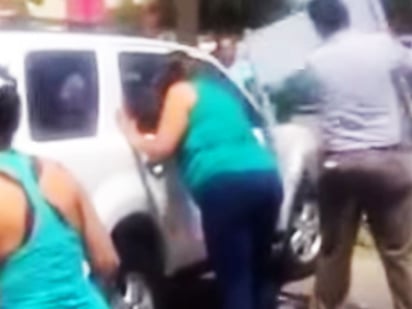 La mujer fue grabada por otras personas que observaban el momento del rescate del menor. (YOUTUBE)