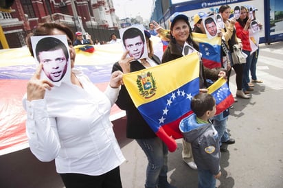 En apoyo. Varias personas portan una máscara alusiva a Leopoldo López y exigen su liberación. La ONU determinó además que es ilegal la detención del político.