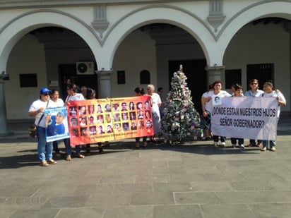 Protesta. Familiares de desaparecidos cuestionaron la actuación del gobernador Javier Duarte, al colocar en Veracruz un pino con los rostros de sus familiares que aún no encuentran.