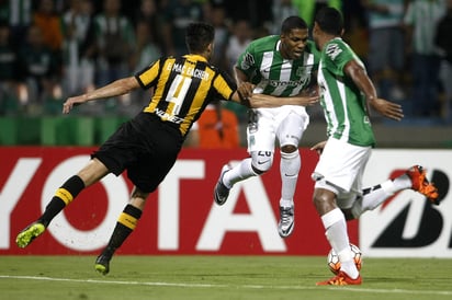 El jugador de Atlético Nacional Orlando Berrio (c) disputa el balón con Emilio Mac Eachen (i) de Peñarol. (EFE)