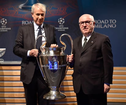 Carlo Tavecchio, presidente de la federación del Calcio italiano (i), y Giuliano Pisapia, alcalde de Milán, posan junto al trofeo que se llevará el campeón de la Liga de Campeones de Europa. (AP)