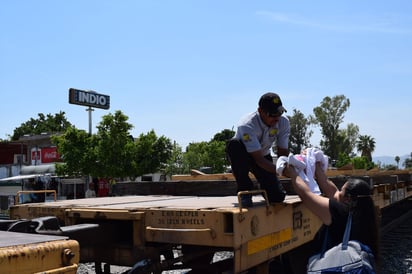 Mujeres con dos bebés en brazos, se vieron forzadas a pedirle a un empleado de seguridad ferroviaria que los cargara y pasara del otro lado de los vagones. (EL SIGLO DE TORREÓN)