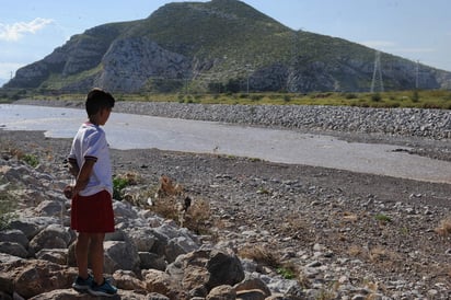 Corre el río otra vez. Un niño observa la punta de la segunda avenida en el año del río Nazas, en el Cañón de las Calabazas, ya en la zona metropolitana de La Laguna. El agua llegó a este sitio a las 5:00 pm de ayer a pesar de que se esperaba que esto ocurriera hasta hoy. (Ramón Sotomayor)