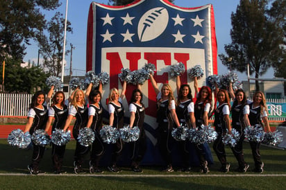 Las porristas de los Raiders posan con el logo gigante de la NFL. 