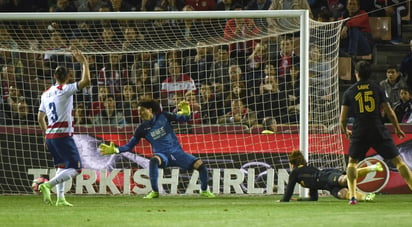 El delantero francés del Atlético de Madrid, Antoine Griezmann (2d), tras cabecear el balón ante el guardameta mexicano del Granada, Francisco Guillermo Ochoa (2i), consiguiendo el gol de la victoria. (EFE)