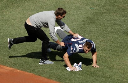 Tom Brady taclea a Rob Gronkowski para obtener de vuelta el jersey luego que el ala cerrada se lo había arrebatado. (AP)