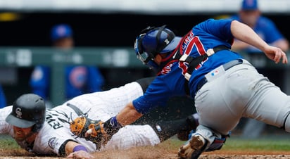 Mark Reynolds llega safe en home para anotar una carrera de los Rockies en la paliza 10-4 sobre los Cachorros de Chicago. (AP)