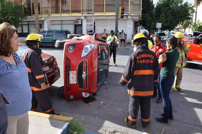 De acuerdo con los peritos el Dodge golpeo al Spark y provocó que éste se volcara y se proyectara contra la unidad estacionada. (ESPECIAL)