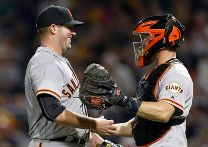 El lanzador Dan Slania (i) es felicitado por su catcher Buster Posey. (AP)