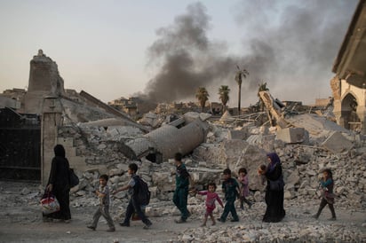 Ruinas. Mujeres y niños observan los restos en donde se encontraba la mezquita de Al Nuri.