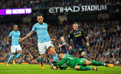 El arquero Ederson (abajo) de Manchester City ataja un balón junto a su compañero Nicolas Otamendi (i). (EFE)