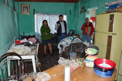 Daños. Rosario Leal  vecina de la calle Escuadrón 201 en la colonia Victoria, muestra al alcalde los daños que sufrió su vivienda  donde el agua alcanzó  altura superior a un metro. (FERNANDO COMPEÁN)