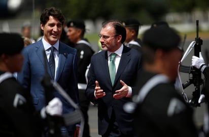 Con una enorme sonrisa y traje color azul, el mandatario dio la mano al canciller mexicano, con quien intercambio palabras, para posteriormente acceder al hangar presidencial. (AP) 