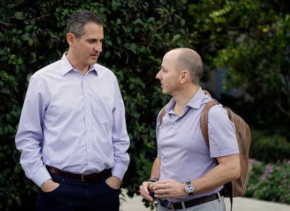 Thad Levine (i) y Brian Cashman, gerentes generales de Twins y Yankees respectivamente, hablan durante las reuniones de gerentes de equipos. Acelerar juegos es el objetivo de GL