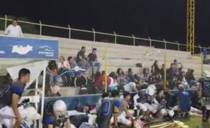 Angustia. Los asistentes al juego de futbol americano buscaron resguardarse durante el tiroteo.