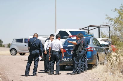 El cuerpo del funcionario presentaba un impacto de bala en la cabeza y quedó tendido a un costado del vehículo en que viajaba. (ARCHIVO)