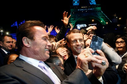 Para el ‘face’. El presidente de Francia, Emmanuel Macron (Der.) y Arnold Schwarzenegger se tomaron una ‘selfie’. (AP)