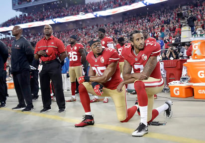 Eric Reid (35) y Colin Kaepernick se arrodillan durante la interpretación de himno de Estados Unidos, en un juego de la temporada pasada. (Archivo)