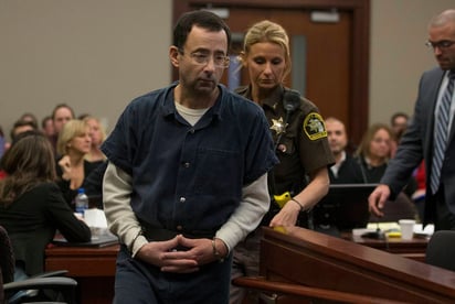 Una oficial conduce a su lugar en corte al médico Larry Nassar, durante los procedimientos judiciales en la fase de su sentencia en Lansing, Michigan. (EFE)