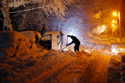 Complicado. Residentes sobre  Mills Street, tratan de limpiar su automóvil que se encuentra debajo de varios centímetros de nieve que cayeron ayer en Morristown, Nueva Jersey. (AP)