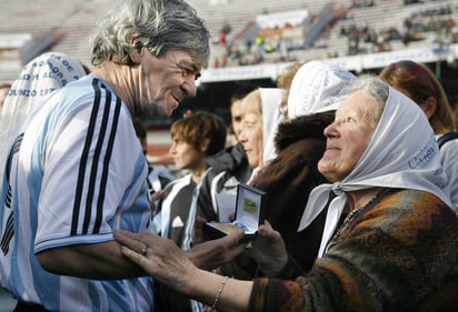 René Orlando Houseman (i) mientras recibe una medalla de la Madre de Plaza de Mayo Nora Cortiñas. (EFE)