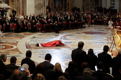 Francisco se postró enfrente del altar al comienzo del servicio nocturno que incluyó cánticos litúrgicos. (AP)