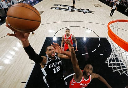 LaMarcus Aldridge, de los Spurs de San Antonio, intenta anotar frente a  Luc Mhah, de los Rockets de Houston. (EFE)