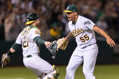 Sean Manaea (d) celebra con Jonathan Lucroy tras el out 27. Manaea lanza juego sin hit ante Boston