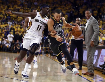 Stephen Curry lleva el balón ante la marca de Jrue Holiday. Vive Curry un regreso triunfal con los Warriors