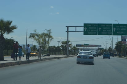 Se arriesgan. Peatones deben correr entre los vehículos para cruzar la carretera a Matamoros, a la altura del Hospital General. (ROBERTO ITURRIAGA)