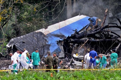 Rescate e inspección. Policías y militares trabajan entre los restos del avión Boeing-737 que se estrelló ayer poco después de despegar del aeropuerto José Martí de La Habana (Cuba).