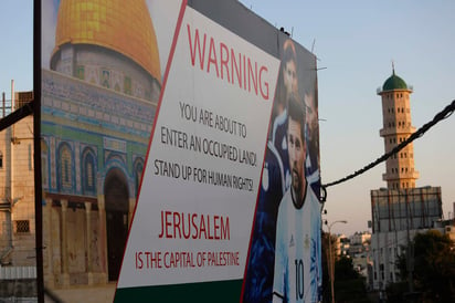 Un cartel que protesta por el partido amistoso entre Israel y Argentina se ve en una calle principal en la ciudad cisjordana de Hebrón mostrando a la superestrella argentina Lionel Messi. (AP)