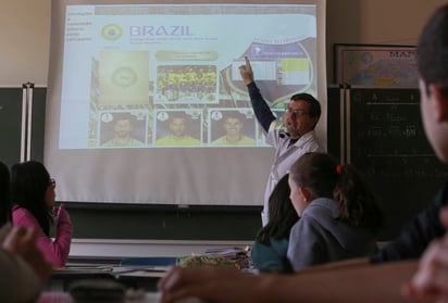 El profesor de octavo grado Ari Mascarenhas pudo haber elegido dispositivos tecnológicos o modernas aplicaciones para impartir sus clases, pero recurrió a la vieja escuela, con el famoso álbum de la Copa del Mundo (AP)