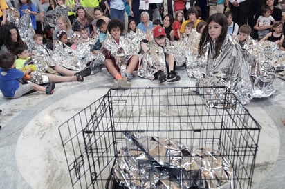 Protesta. Niños cubiertos con mantas plateadas de emergencia y sus padres se manifiestan en el edificio Russell del Senado. (EFE)