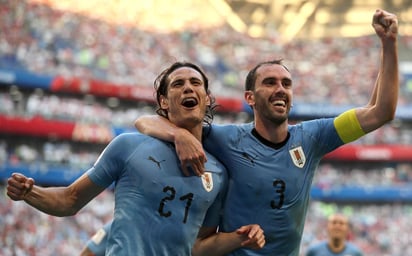 Edinson Cavani (i) celebra con Diego Godín tras el tercer tanto del juego anotado por el delantero del París Saint-Germain. Uruguay cerró la fase de grupos en la cima del sector A con nueve puntos. (EFE)