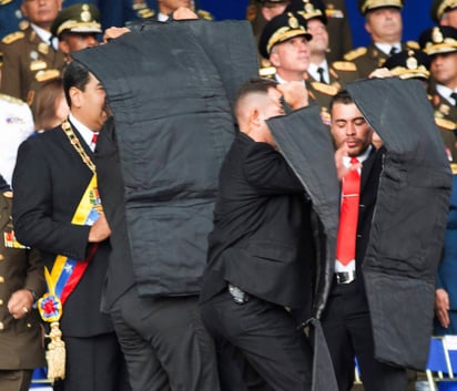 Reacción. Luego de una primera explosión, el presidente venezolano Nicolás Maduro (con la banda presidencial)  fue resguardado de inmediato por sus escoltas, luego de un supuesto atentado en su contra ayer durante un acto público con militares en Caracas. 