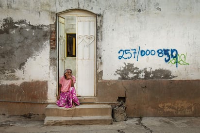 Una habitante del Itsmo de Tehuantepec, a la entrada de una vivienda marcada para su reconstrucción en el estado de Oaxaca, México. Foto: EFE/Luis Villalobos