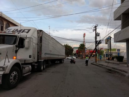 La caja se atoró con los cables y al continuar el tráiler con su trayectoria, derribó dos postes de madera. (EL SIGLO DE TORREÓN)